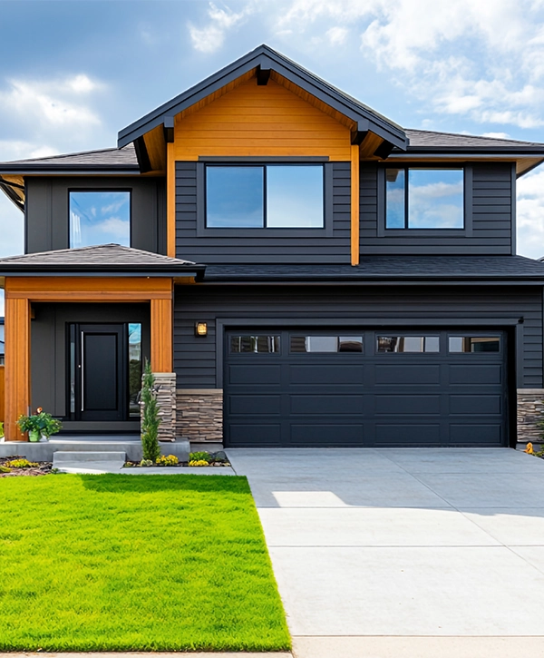 Modern two story house with gray siding orange accents and a large driveway